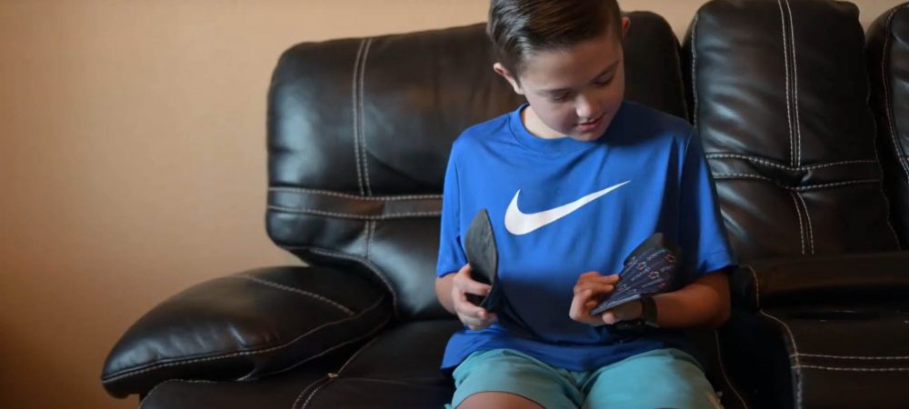 Kid sitting in softly lit room, looking at a custom orthotic insert.